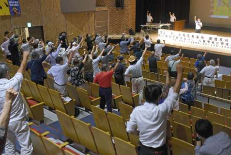 「基地反対」の気勢を上げる参加者＝西之表市民会館
