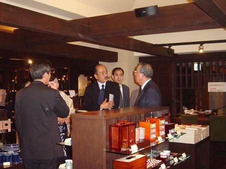 濵田雄一郎さん（中央）の案内で蔵を見学する稲盛和夫さん（右）＝２００５年５月（濵田酒造提供）