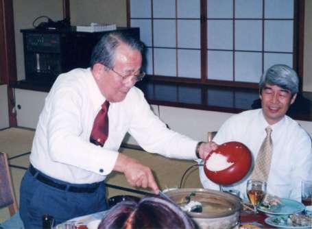 盛和塾の新年会で、自ら雑炊を作る稲盛和夫さん。右は島津公保さん＝２００１年１月、鹿児島市内のホテル（島津さん提供）