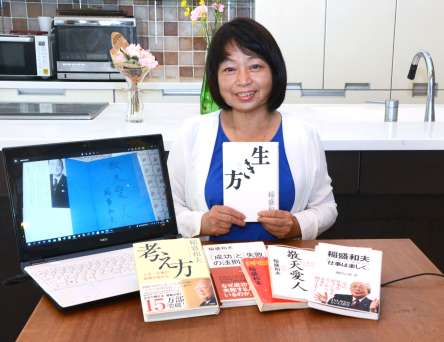稲盛さんの著書を持つ赤尾かおりさん。パソコン画面は本人に書いてもらった「敬天愛人」＝鹿児島市