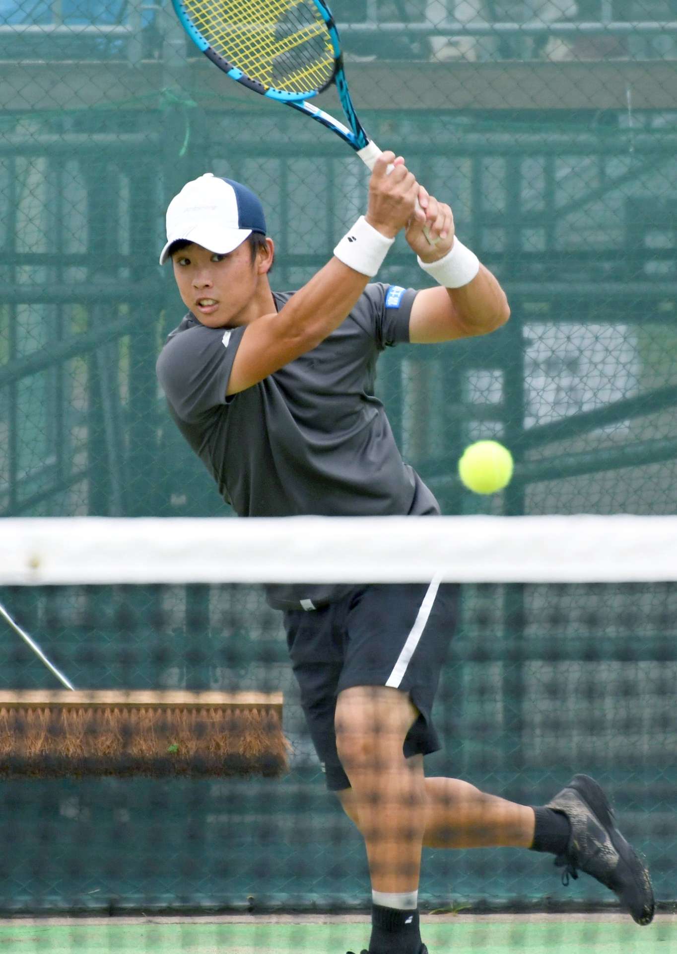 成年男子決勝、鋭いバックハンドで攻める齋藤惠佑（県スポ協）＝宇都宮市屋板運動場