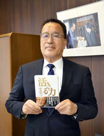 稲盛さんの著書を手にする武隈晃さん＝鹿児島大学