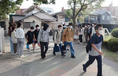 自由な服装で登校する生徒たち＝８日午前７時４７分、鹿児島市の鴨池中学校
