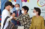 署名した人にブルーリボンを着ける特定失踪者の家族ら＝１０日、鹿児島市