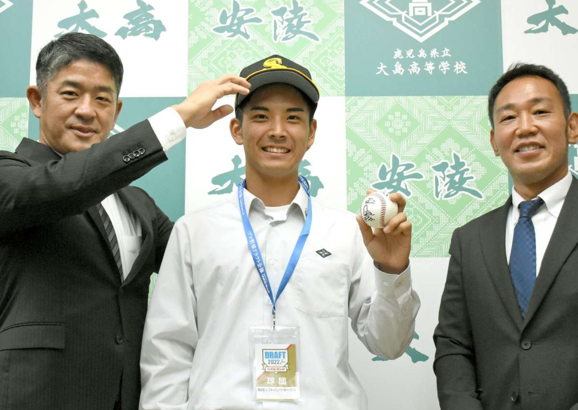ソフトバンクの帽子をかぶり笑顔を見せる大野稼頭央投手（中央）と球団スカウト＝大島高校