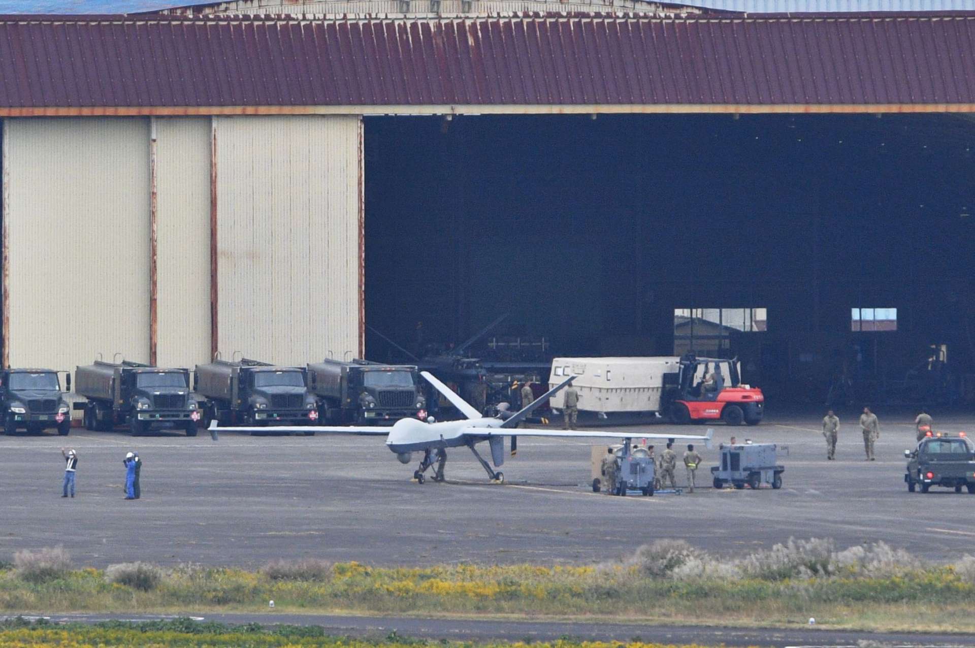 海上自衛隊鹿屋航空基地で無人偵察機「ＭＱ９」を整備する米軍関係者＝２７日午後２時２８分、鹿屋市野里町