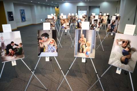 【別カット】ずらりと育児休業中の父親らの写真が並ぶ会場＝鹿児島市のかごしま県民交流センター