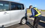通行車両に消毒液を噴霧する係員＝５日、出水市荘