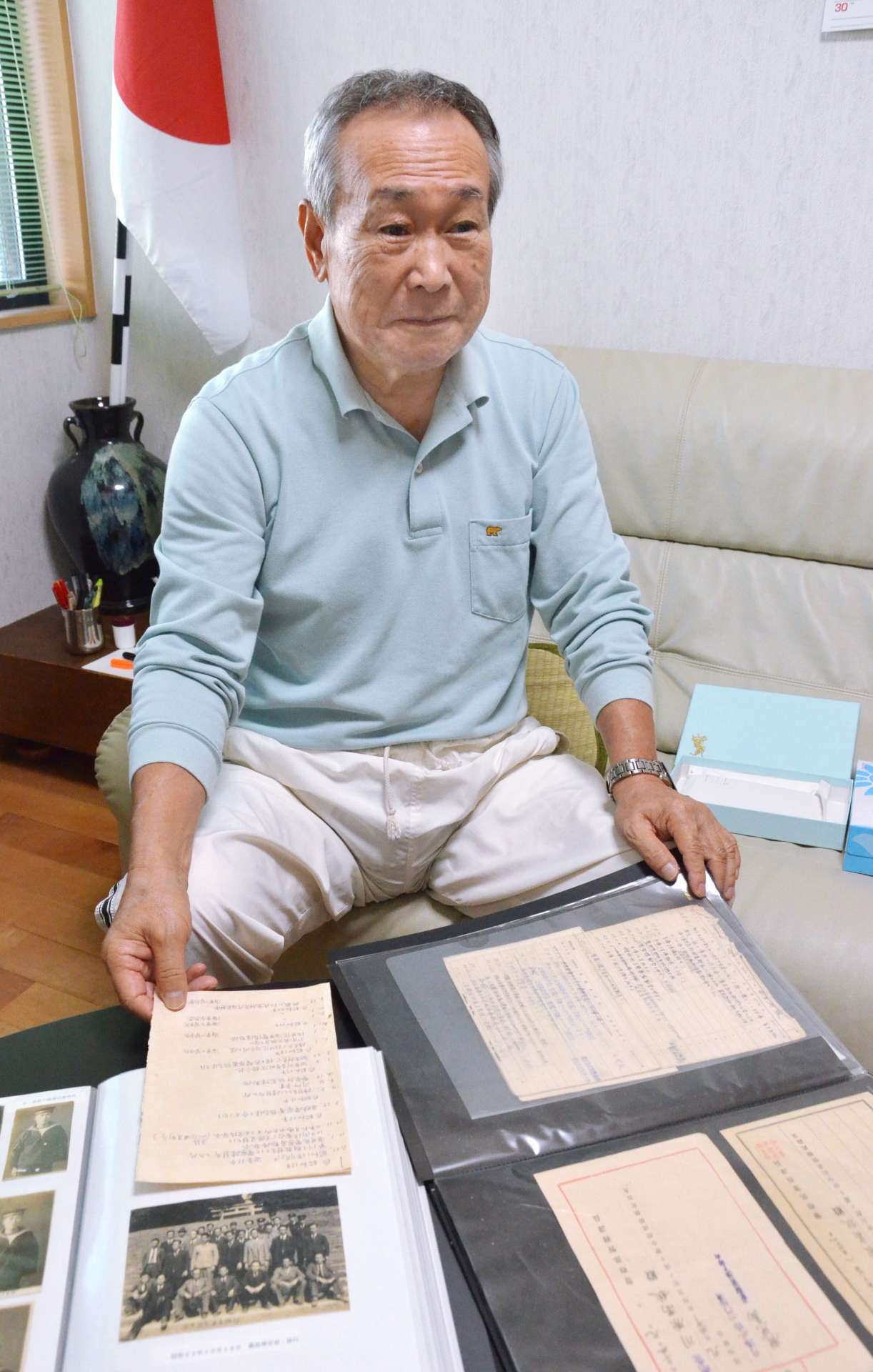 父の残した戦争の遺品をファイリングし、末代に語り継ぐ川原裕さん＝２２日午後４時１７分、鹿児島市上福元町