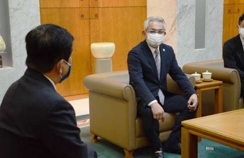 ウクライナ支援の義援金贈呈で塩田康一知事（左）を訪問したフェニックスの岩元浩海社長＝鹿児島県庁