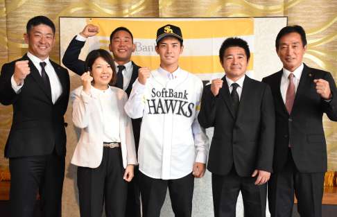 スカウト陣と両親に囲まれ笑顔を見せる大野稼頭央投手＝奄美市名瀬