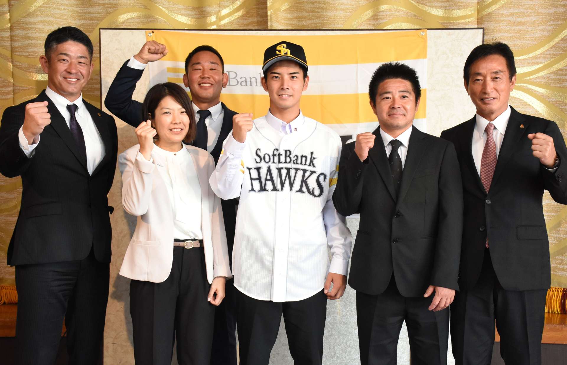 スカウト陣と両親に囲まれ笑顔を見せる大野稼頭央投手＝奄美市名瀬