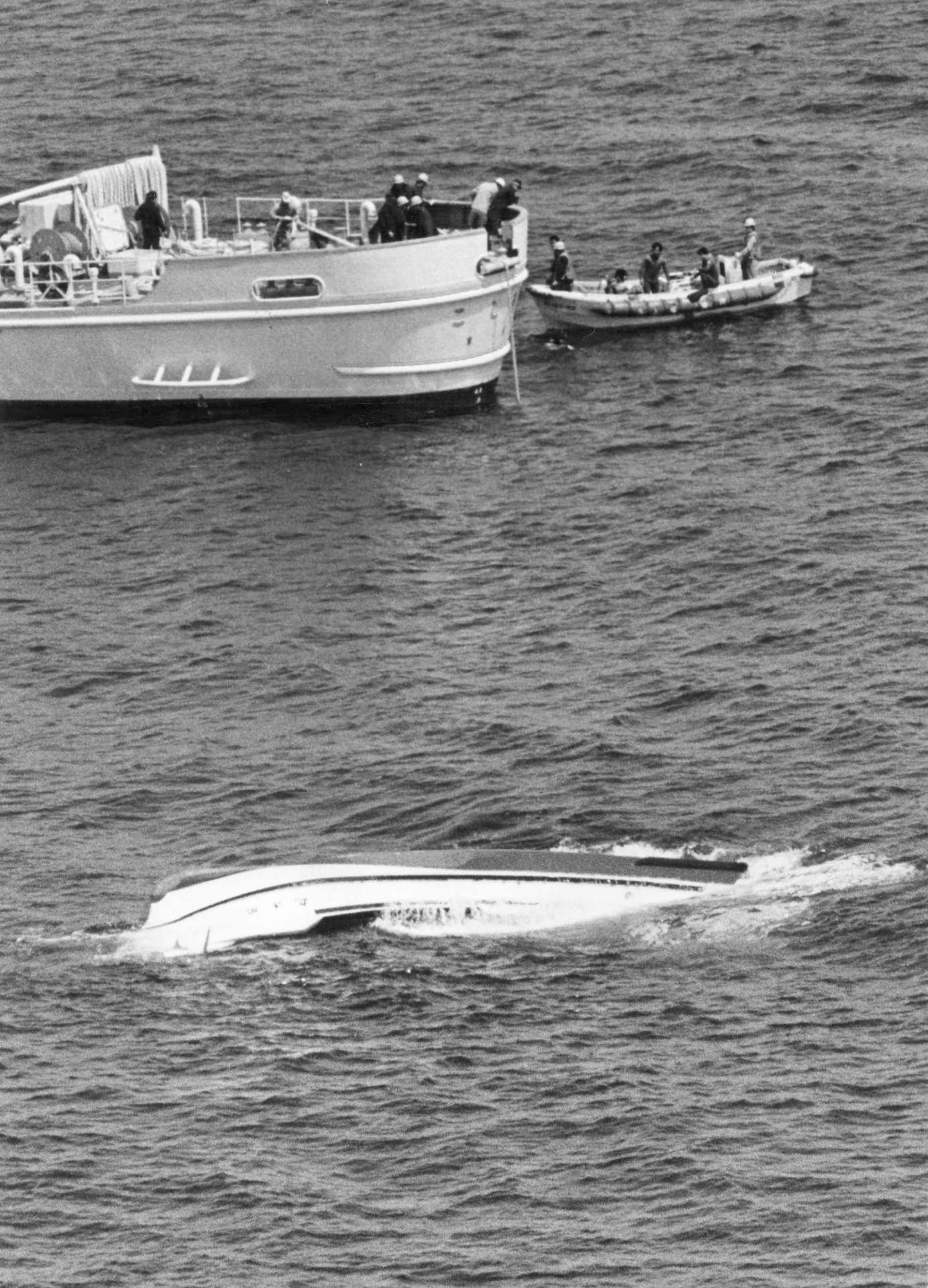 坊ノ岬の南西４キロ付近を白い船体を横転し漂流する開洋丸＝１９８５（昭和６０）年４月１日