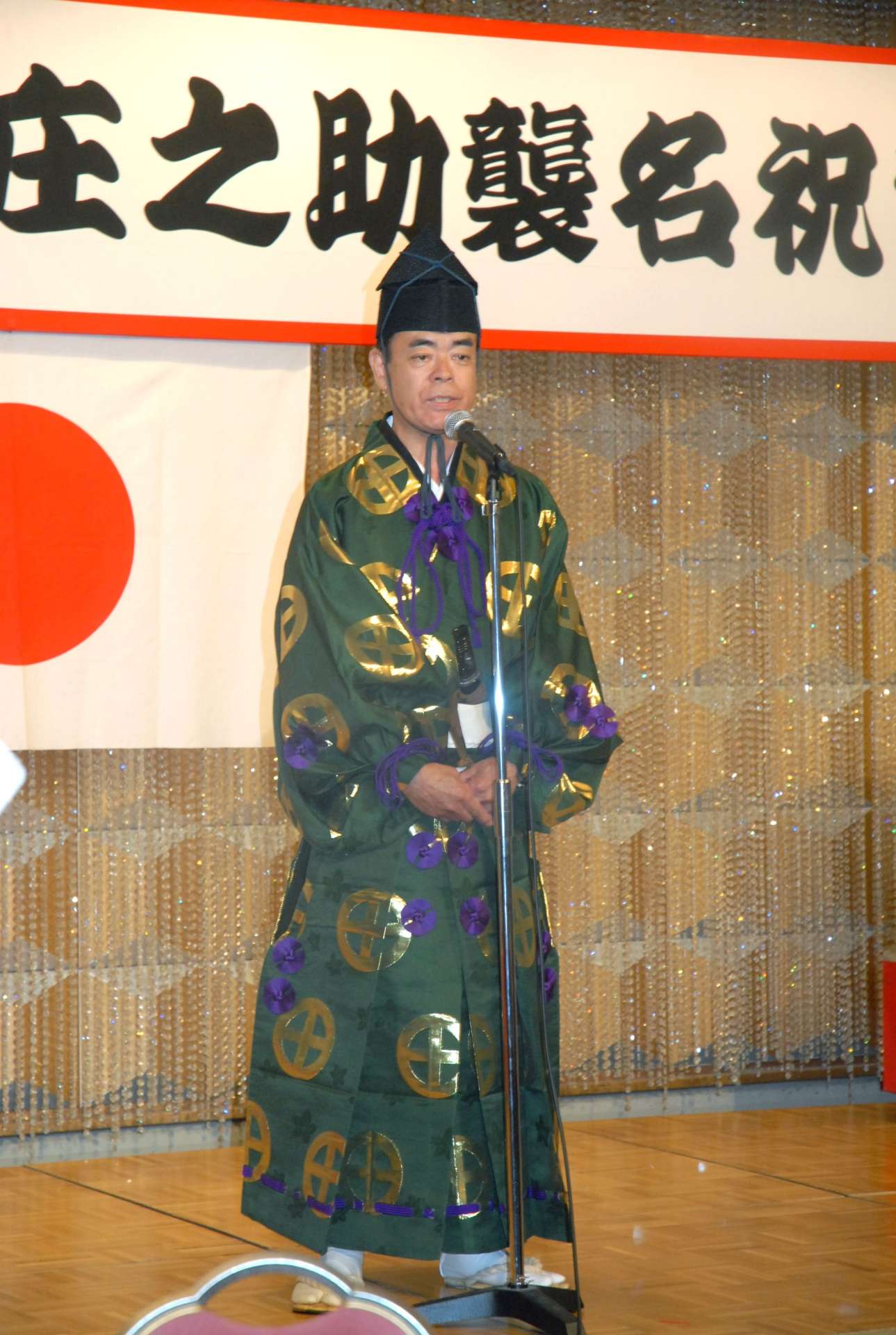 ２０１１年１１月、第３６代木村庄之助の襲名祝賀会で決意を述べる山崎敏廣さん＝鹿児島市