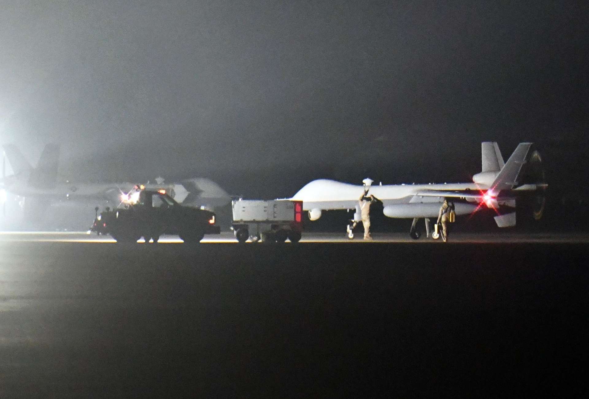 運用初日の飛行を終え、海上自衛隊鹿屋航空基地に戻った米空軍無人偵察機ＭＱ９（右）＝２２日午前１時４３分、鹿屋市今坂町