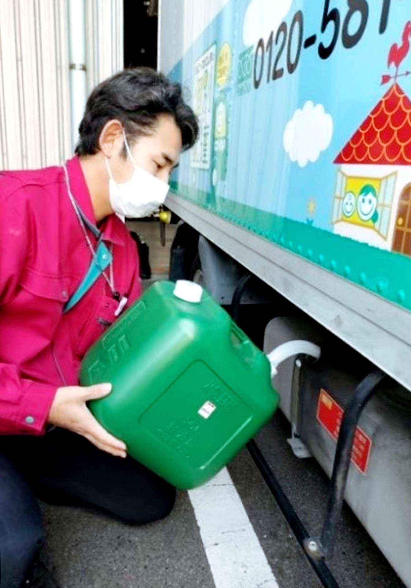 高純度バイオディーゼル燃料混合の軽油をトラックへ給油する職員（生協コープかごしま提供）