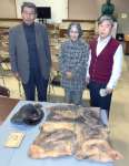 戊辰戦争や西南戦争に従軍した佐土原才助の遺品を寄贈する子孫の山下京子さん（中央）。遺品は（左上から時計回りに）陣がさ、陣羽織、獄中日記＝鹿児島市の西郷南洲顕彰館