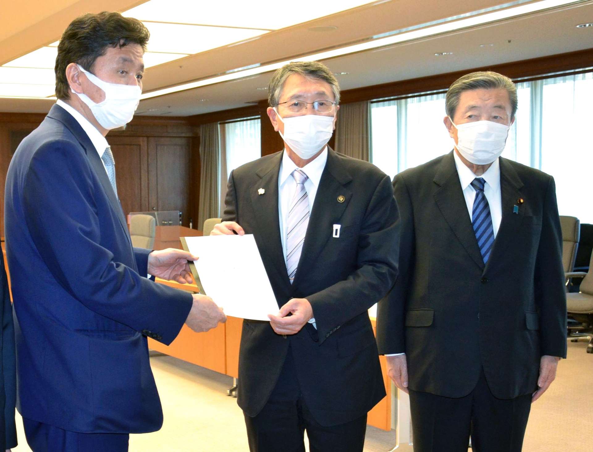 岸信夫防衛相（当時、左）に要望書を手渡す八板俊輔市長（中央）＝２０２２年２月３日、防衛省