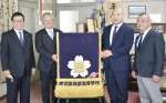 化粧まわしを返還した里山浩作さん（右から２人目）と受け取った鹿児島商業高校の堀之内尚郎校長（同３人目）＝２４日、鹿児島市西坂元町の同校