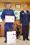 表彰を受けた県警警察犬係長の福留明光さん（左）と警察犬ドリル＝２７日、鹿児島市東開町の鹿児島南警察署