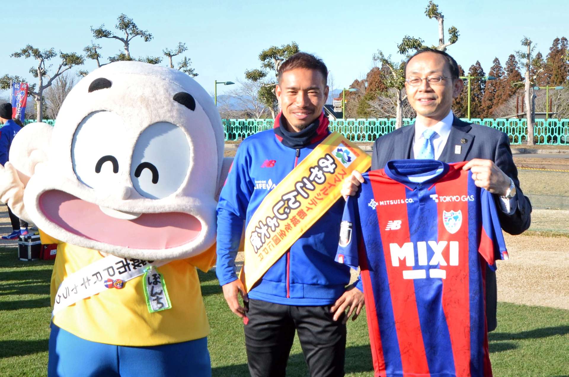 都城市ＰＲキャラクターのぼんちくんや池田宜永市長と写真に収まる長友佑都選手（中央）＝１月３１日、同市の高城運動公園