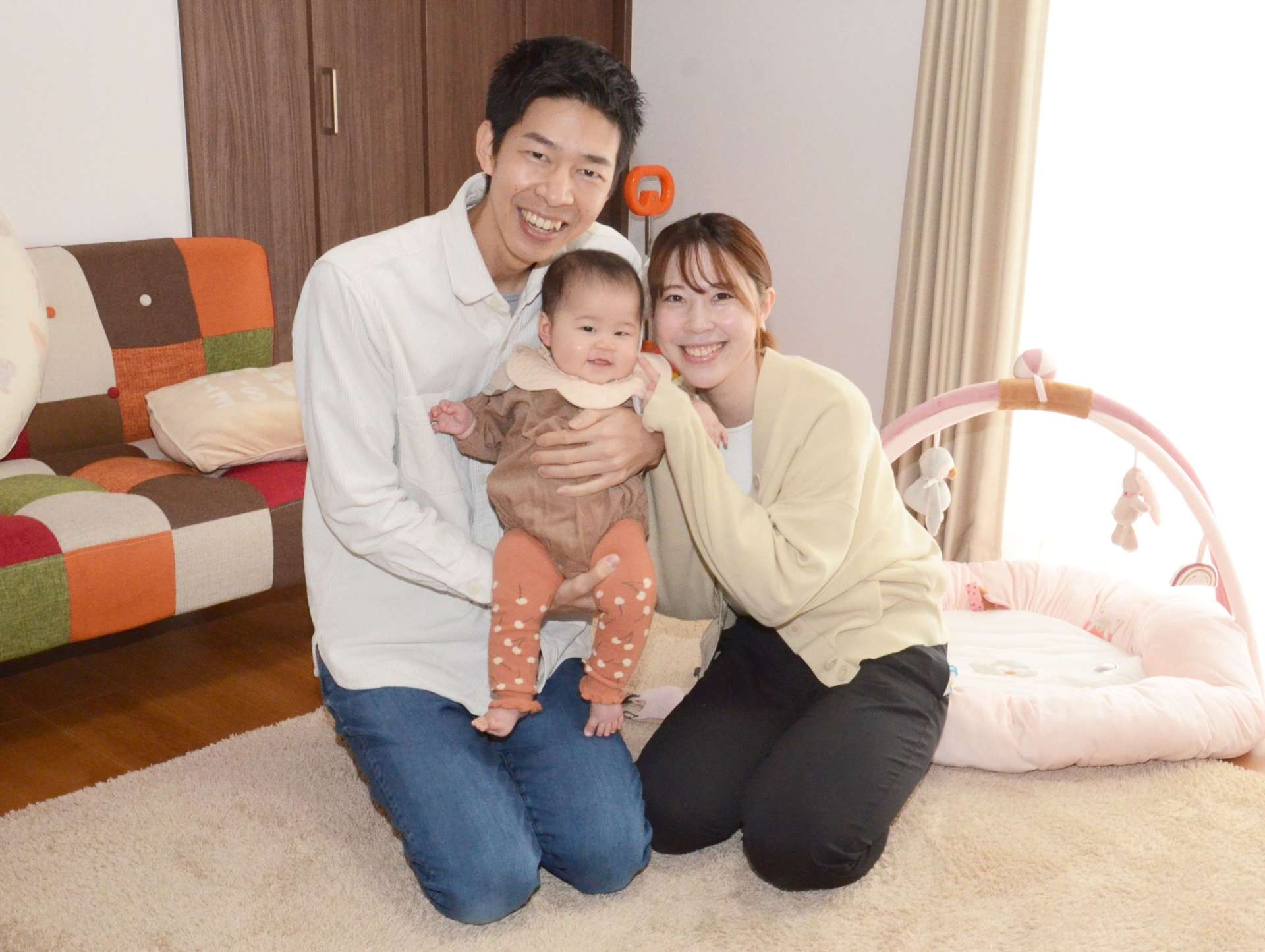 妻の莉歩さんと長女を抱く宮薗航大さん。「育休を取って愛情がさらに深まった」と話す＝２月１１日、出水市