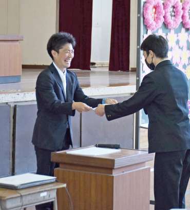 笑顔で卒業証書を手渡す坂元宏輝教諭（左）＝１４日、南大隅町根占川北の神山小学校