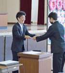 笑顔で卒業証書を手渡す坂元宏輝教諭（左）＝１４日、南大隅町根占川北の神山小学校