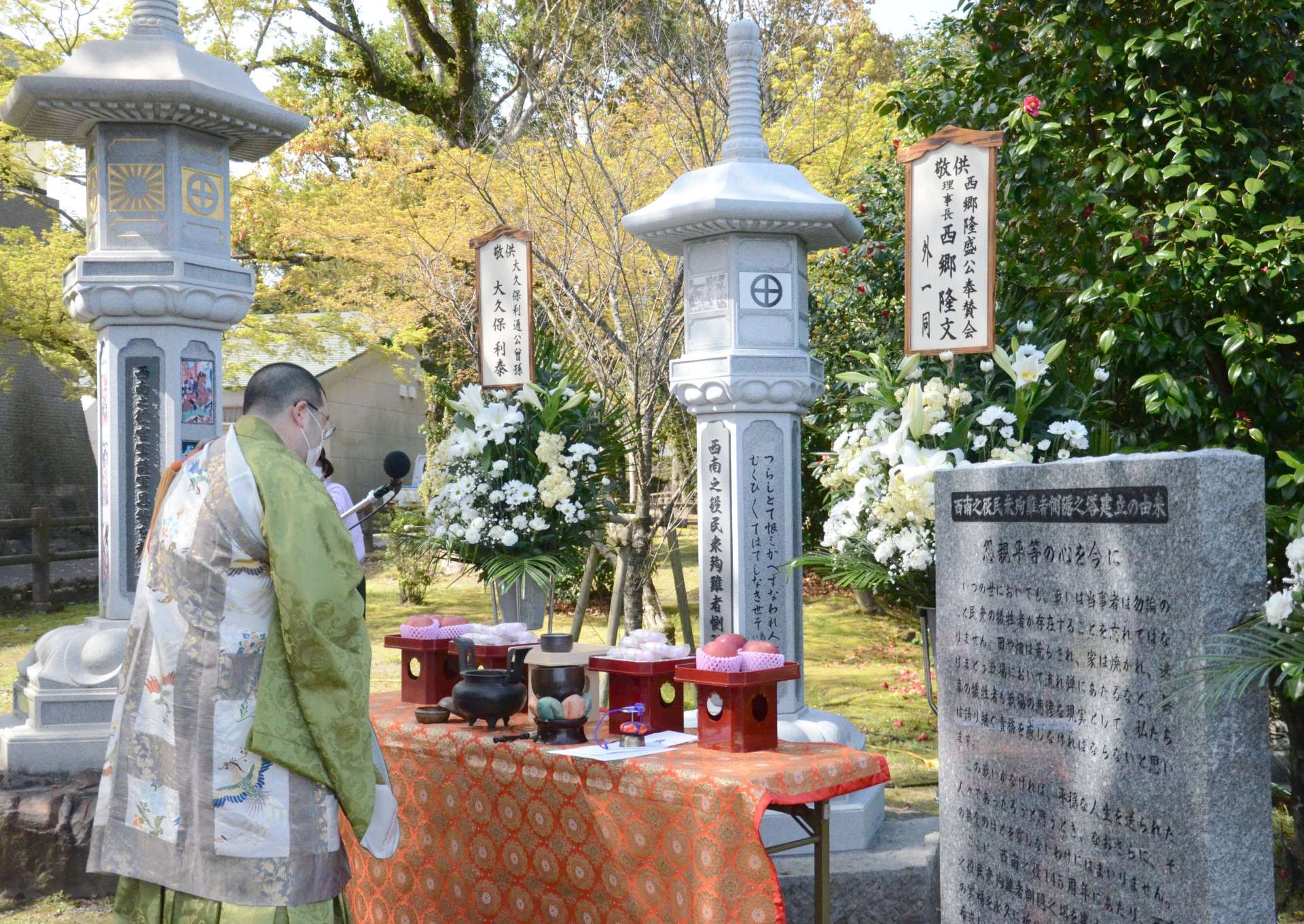 除幕した慰霊塔の前で読経する僧侶＝鹿児島市上竜尾町の南洲公園
