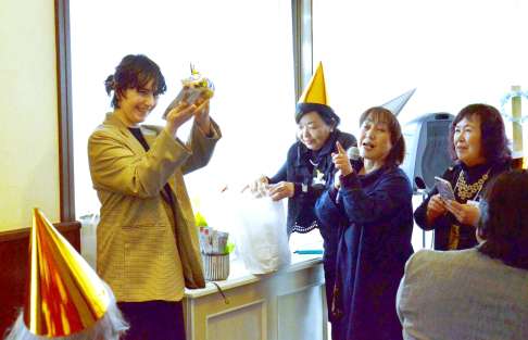 手作りのプレゼントに喜ぶウクライナ人（左）＝鹿児島市武岡１丁目の巴里市場