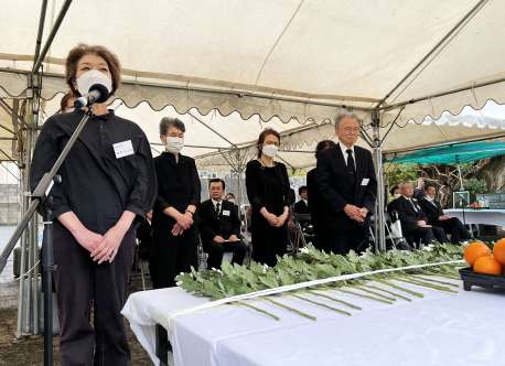 式典で献花の後「またいつか（来るね）」と語りかける愛媛県富山丸遺族会の遺族＝１９日、徳之島町亀徳のなごみの岬公園