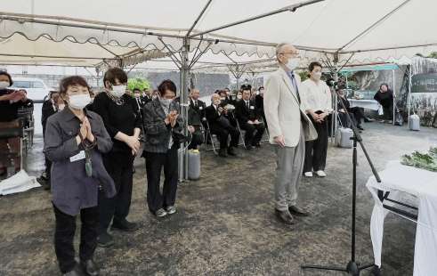 式典で献花の後「お父さん来たよ」と語りかける徳島県富山丸遺族会の遺族＝１９日、徳之島町亀徳のなごみの岬公園