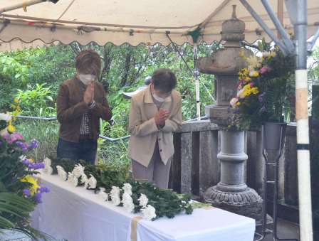 供養塔の前で手を合わせる遺族＝２０日、瀬戸内町古仁屋の森山公園