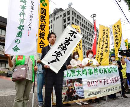 再審請求が退けられ「不当決定」の旗を掲げる弁護団＝５日午前１１時５分、宮崎市の福岡高裁宮崎支部