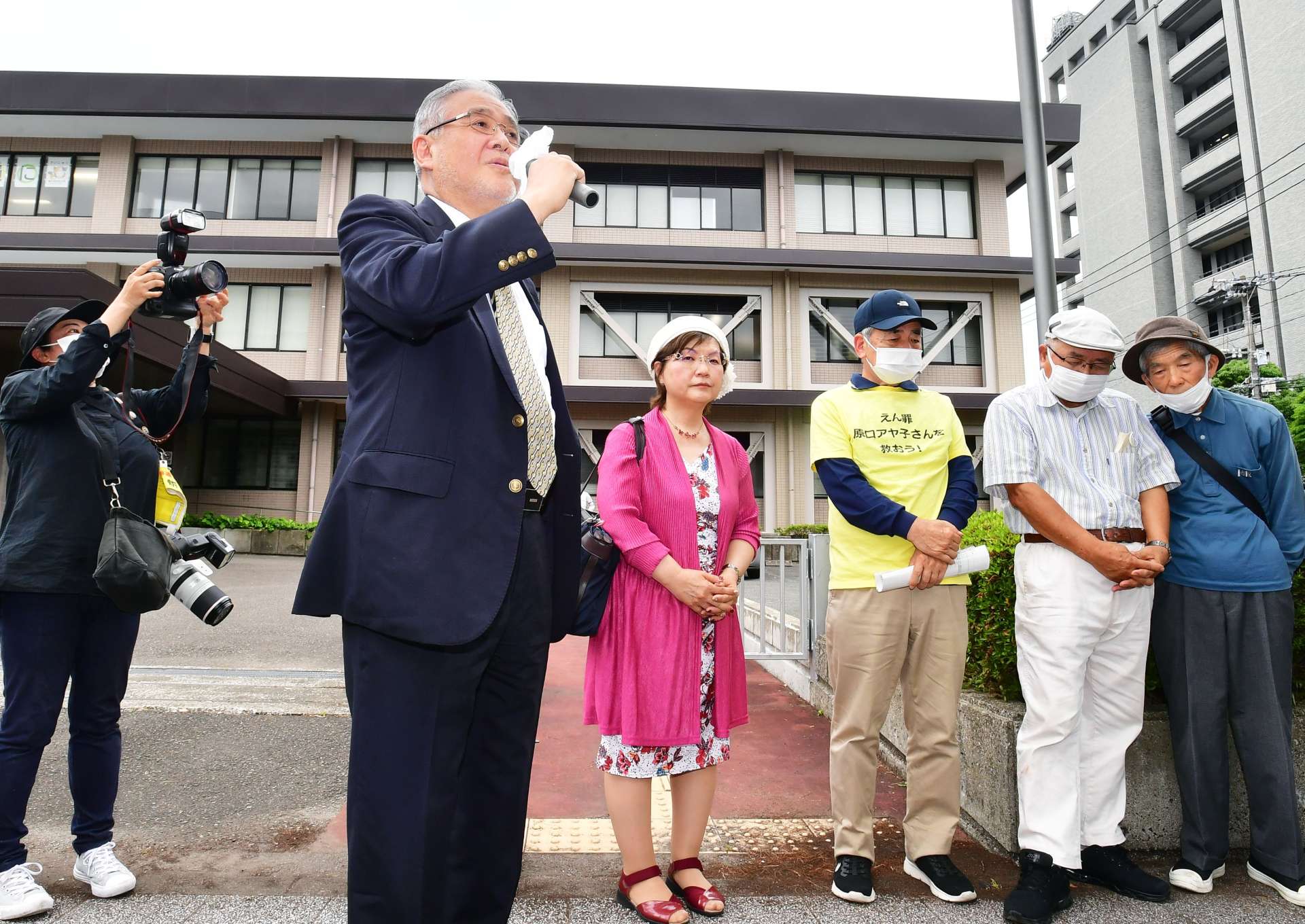 裁判所に入る前、支援者にあいさつする大崎事件の森雅美弁護団長（左）ら＝５日午前、宮崎市の福岡高裁宮崎支部