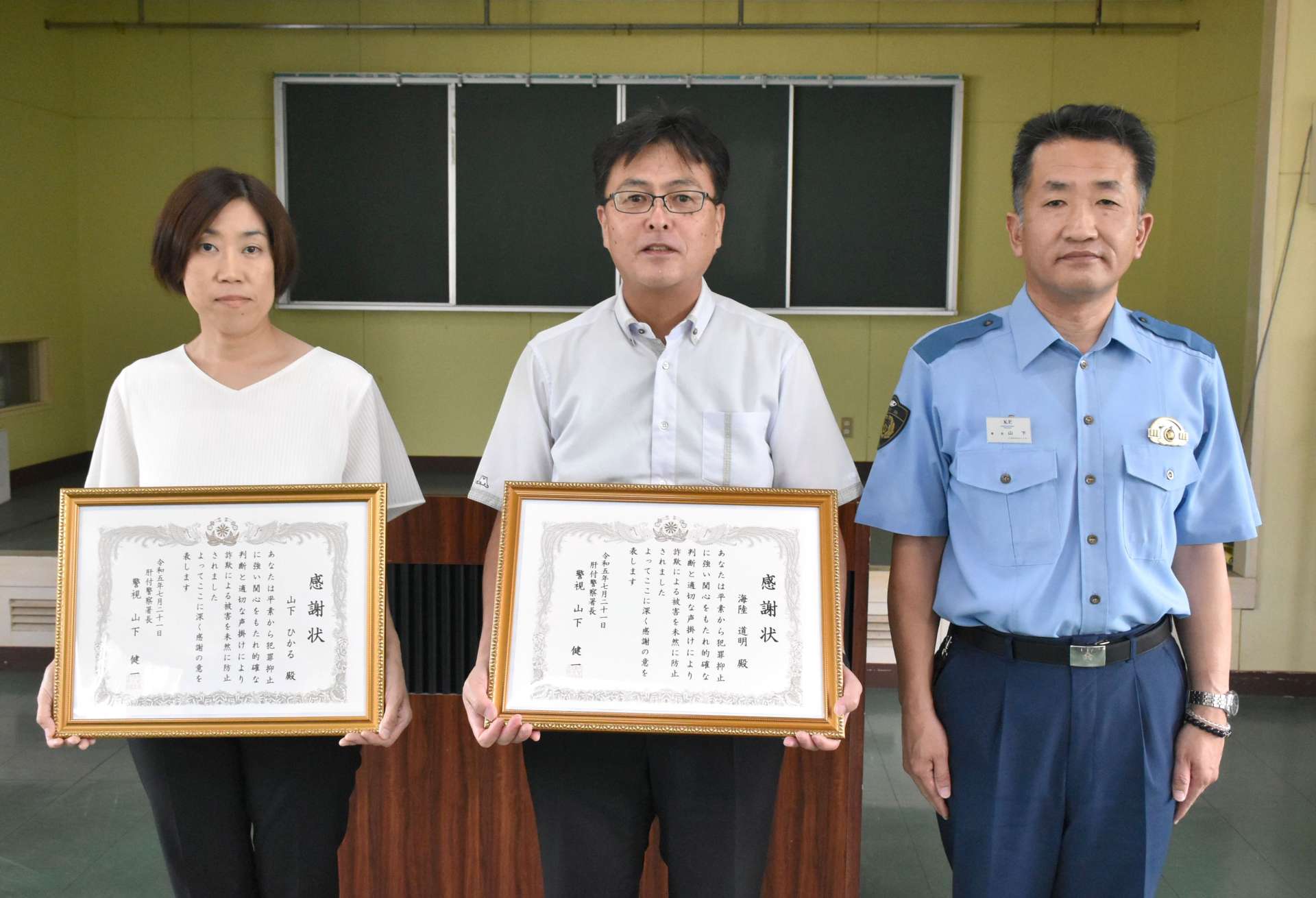 表彰を受けた鹿児島銀行内之浦代理店の海陸道明店長（中央）と、行員の山下ひかるさん（左）、肝付警察署の山下健一署長＝肝付警察署