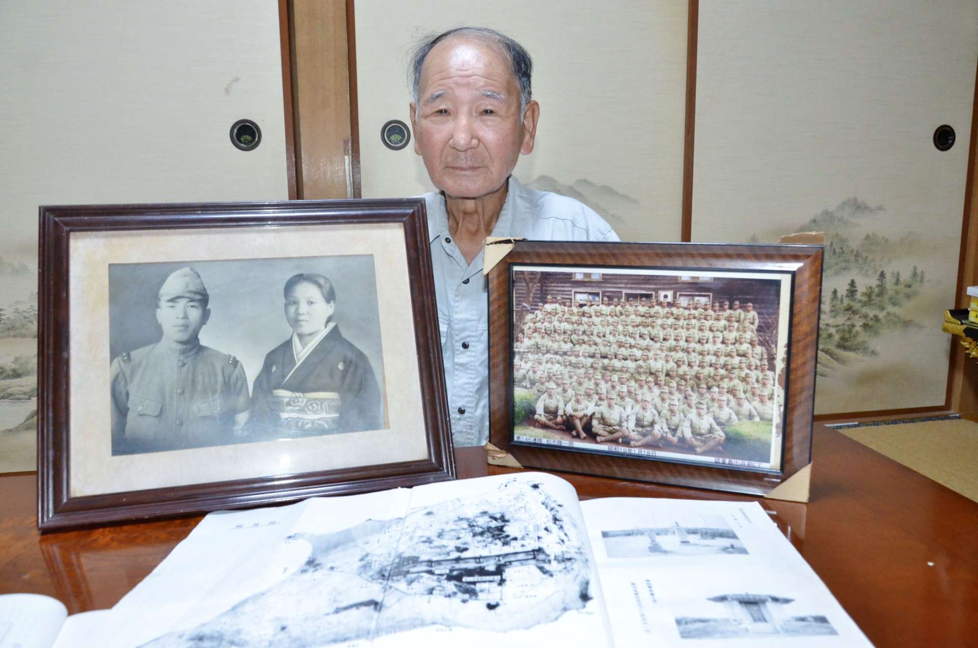 両親らの遺影を手に、遺骨収集を振り返る野瀬純弘さん＝１日、いちき串木野市金山下