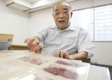 ５０年前の写真を前に当時を振り返る竹之下和雄さん＝４日、東京・新橋