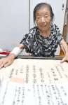 父・一之さんの遺言書や大学の卒業証書を手に持つ迫田清美さん