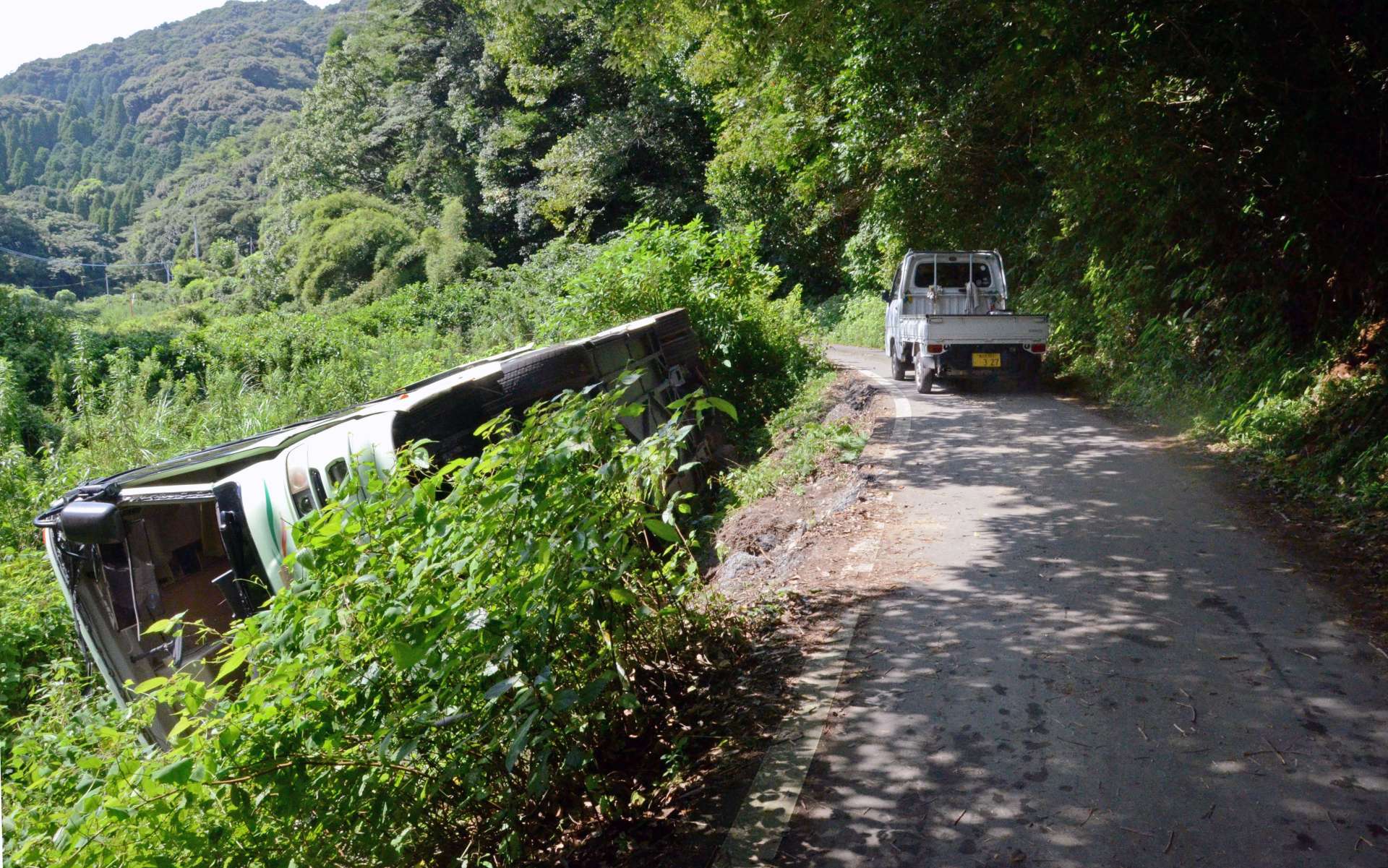 バスが横転した県道。軽トラックが通るので精いっぱいの道幅＝２０日、鹿児島市春山町