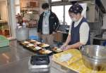 〈資料写真〉２０２１年２月、作業員の昼食用の弁当をチェックする稲村光弘さん（左）＝福島県広野町