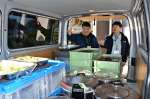 〈資料写真〉２０２１年２月、配送車に積んだ作業員の昼食をチェックする稲村光弘さん（右）＝福島県広野町