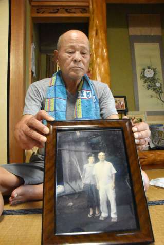 被災した両親の遺影を手にする畠中實さん。３日の慰霊式で遺族代表を初めて務める＝南さつま市金峰町尾下