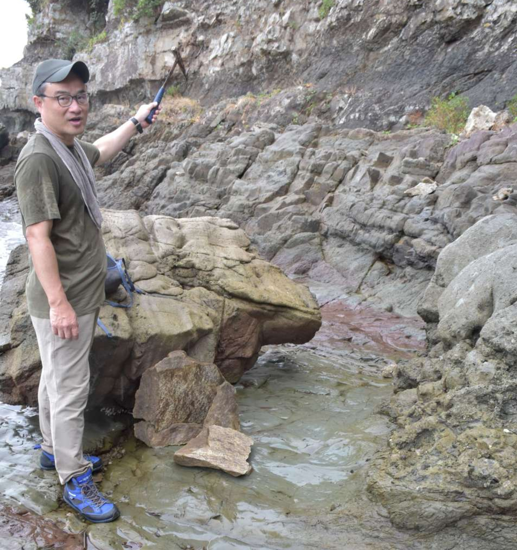３カ所目のボーンベッドで周囲の地層を説明する宇都宮聡さん＝１日、長島町獅子島