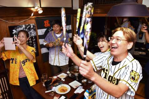 優勝が決まり、歓声を上げる阪神ファン＝１４日、鹿屋市向江町