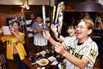 優勝が決まり、歓声を上げる阪神ファン＝１４日、鹿屋市向江町