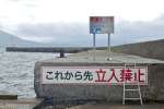 立ち入り禁止の看板がありつつも、上に上がるためのはしごがかけられている堤防＝鹿児島市鴨池新町の鴨池港フェリーターミナル