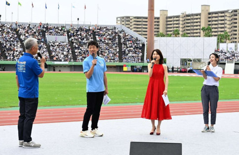 鹿児島国体の開会式オープニングプログラムに登場した迫田孝也さん（左から２番目）。司会の恵俊彰さん（左）、シンガーソングライターの辛島美登里さん（右から2人目）らと会場を盛り上げた＝白波スタジアム