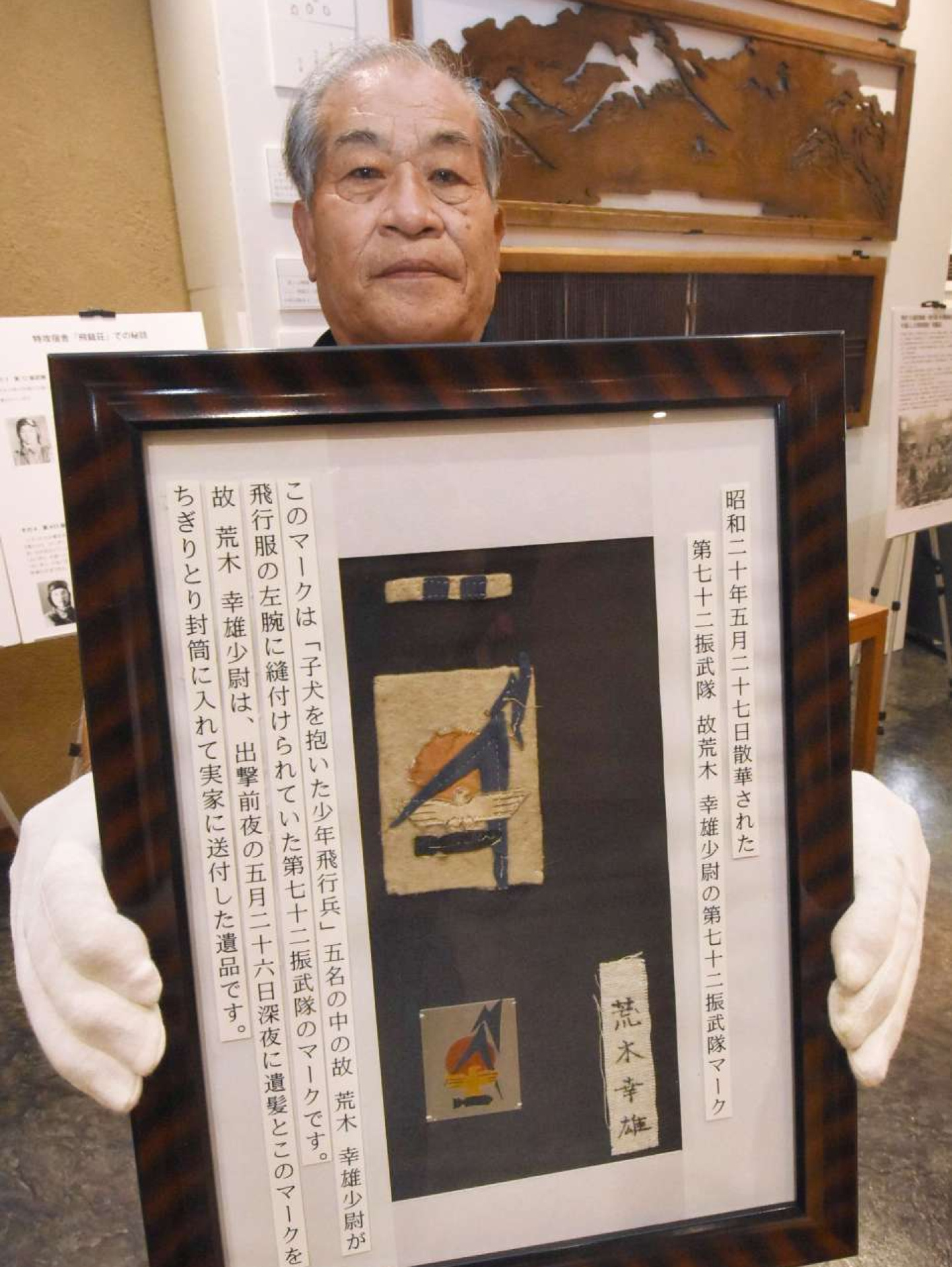 第７２振武隊の荒木幸雄少尉の袖マーク。後ろは飛龍荘の欄間＝南さつま市の万世特攻平和祈念館