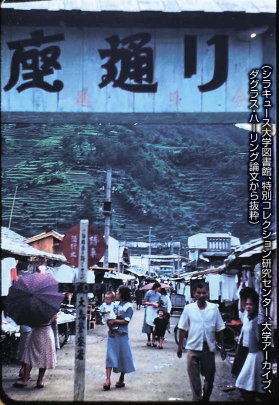 奄美市名瀬の商店街「銀座通り」。衣料品店が中心で、本土や沖縄から仕入れていたとされる。後ろの山では食糧難を解消するため段々畑を耕した（シラキュース大学図書館、特別コレクション研究センター、大学アーカイブ、ダグラス・ハーリング論文から抜粋）